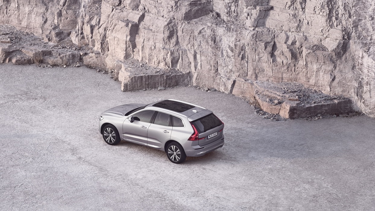 암벽 옆에 있는 파노라마 루프의 은색 볼보 XC60.